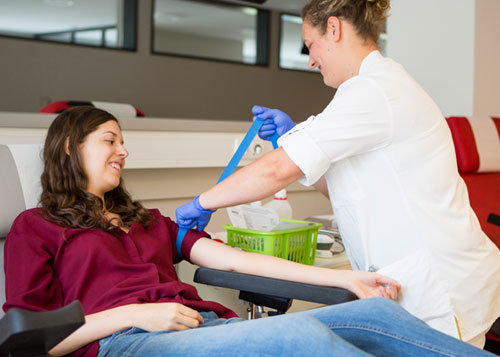 Phlebotomist drawing blood from another woman